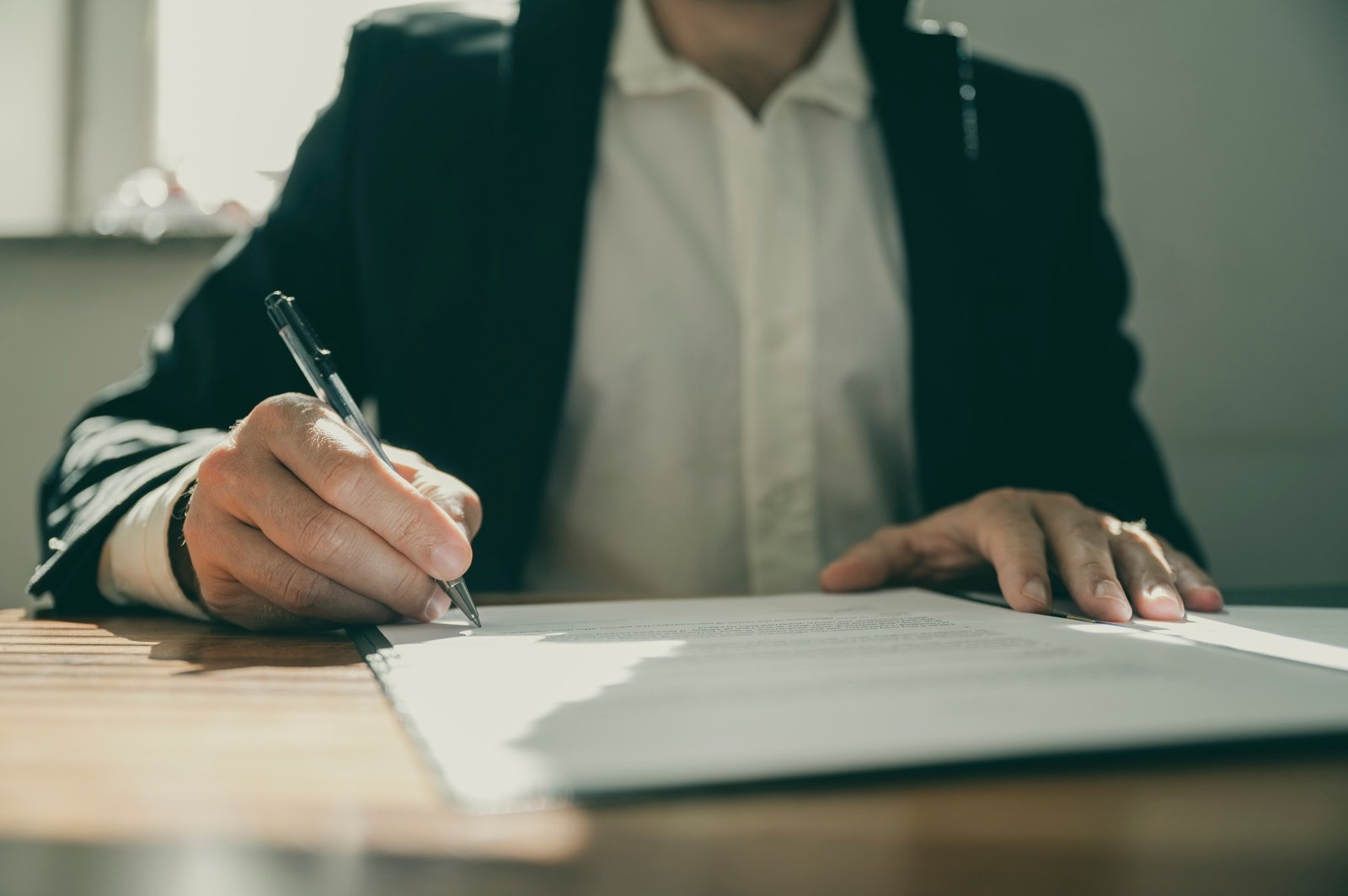 Front view of a torso of a businessman or a lawyer signing a contract